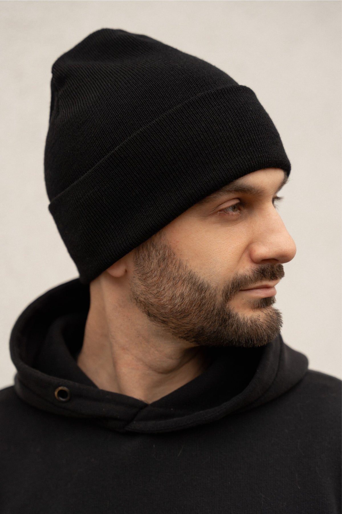 mężczyzna bokiem w czapce merino czarna męska – klasyczny fason beanie premium. Sportowy styl z elegancją. 
