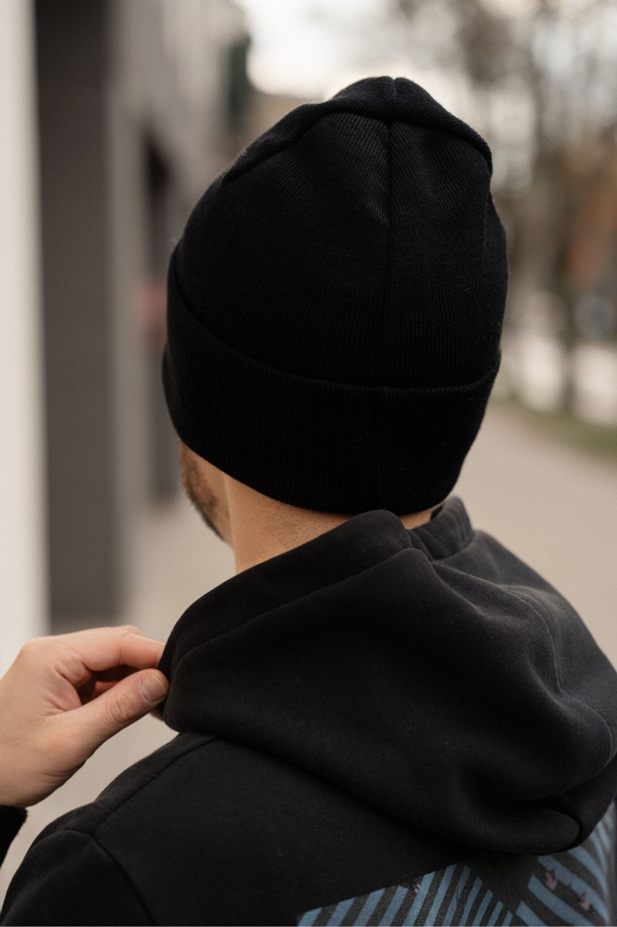 mężczyzna w czapce od tułu. Wygodny miejski sportowy styl.