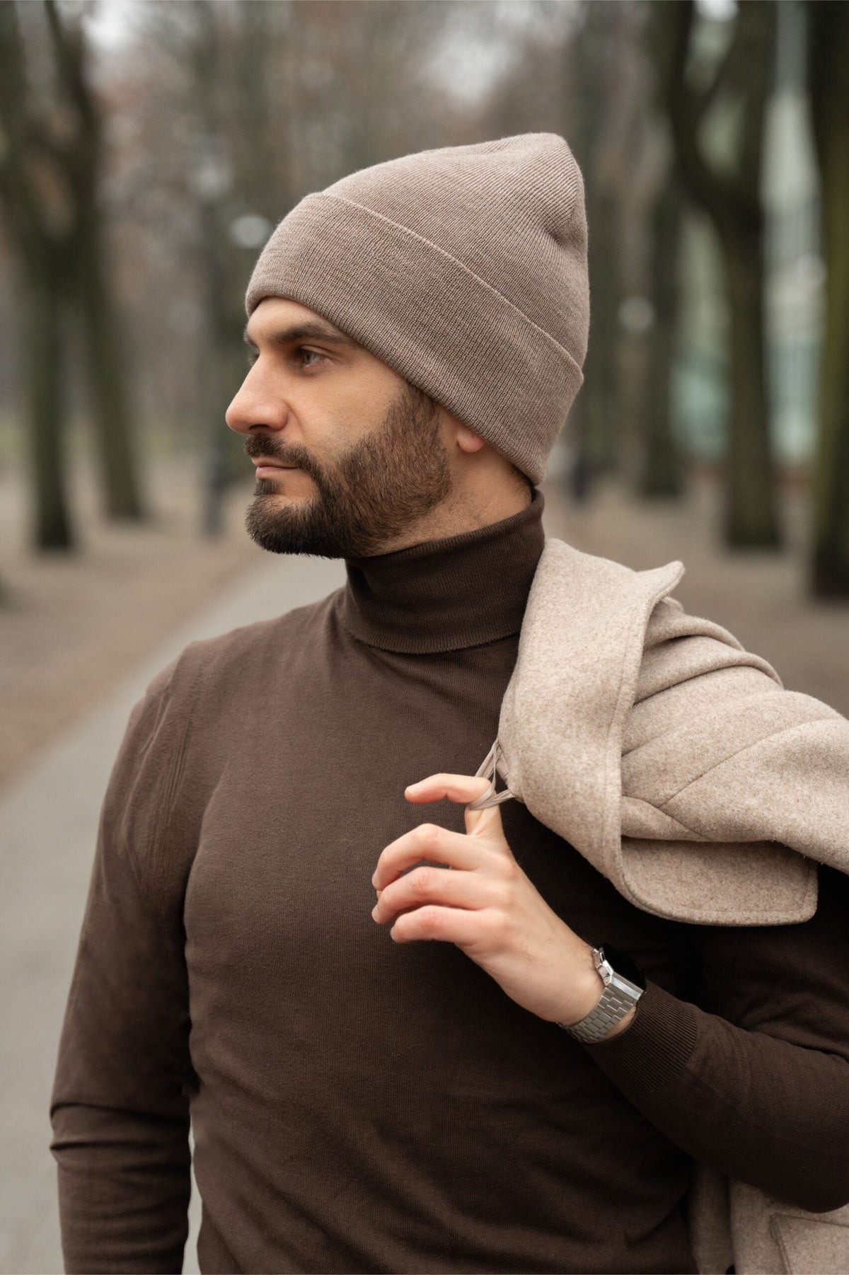 Męska czapka beanie NAOMI z wełny merino – kolor taupe premium na modelu w parku. 