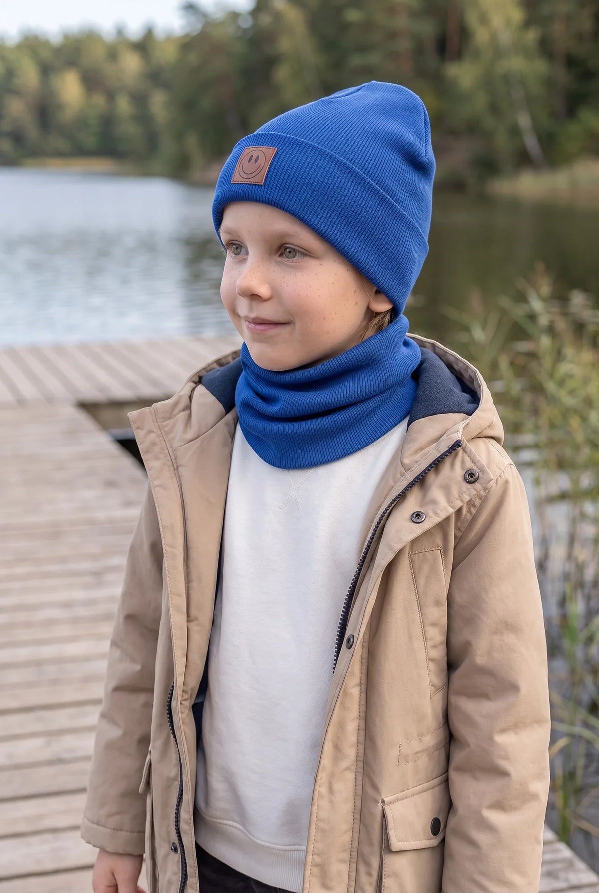 Dziecko w komplecie czapka i komin SMILE, kolor chabrowy – ujęcie pod kątem.