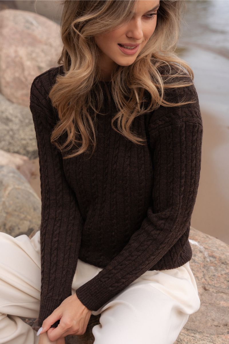 Sweter POLO z wełny merino w kolorze czekoladowego brązu — zbliżenie na warkoczowy splot i długie rękawy na modelce